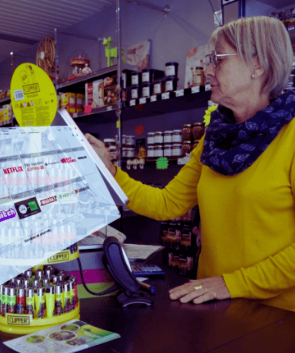 Femme dans un magasin regardant un panneau publicitaire Clipper tout en se tenant au comptoir.