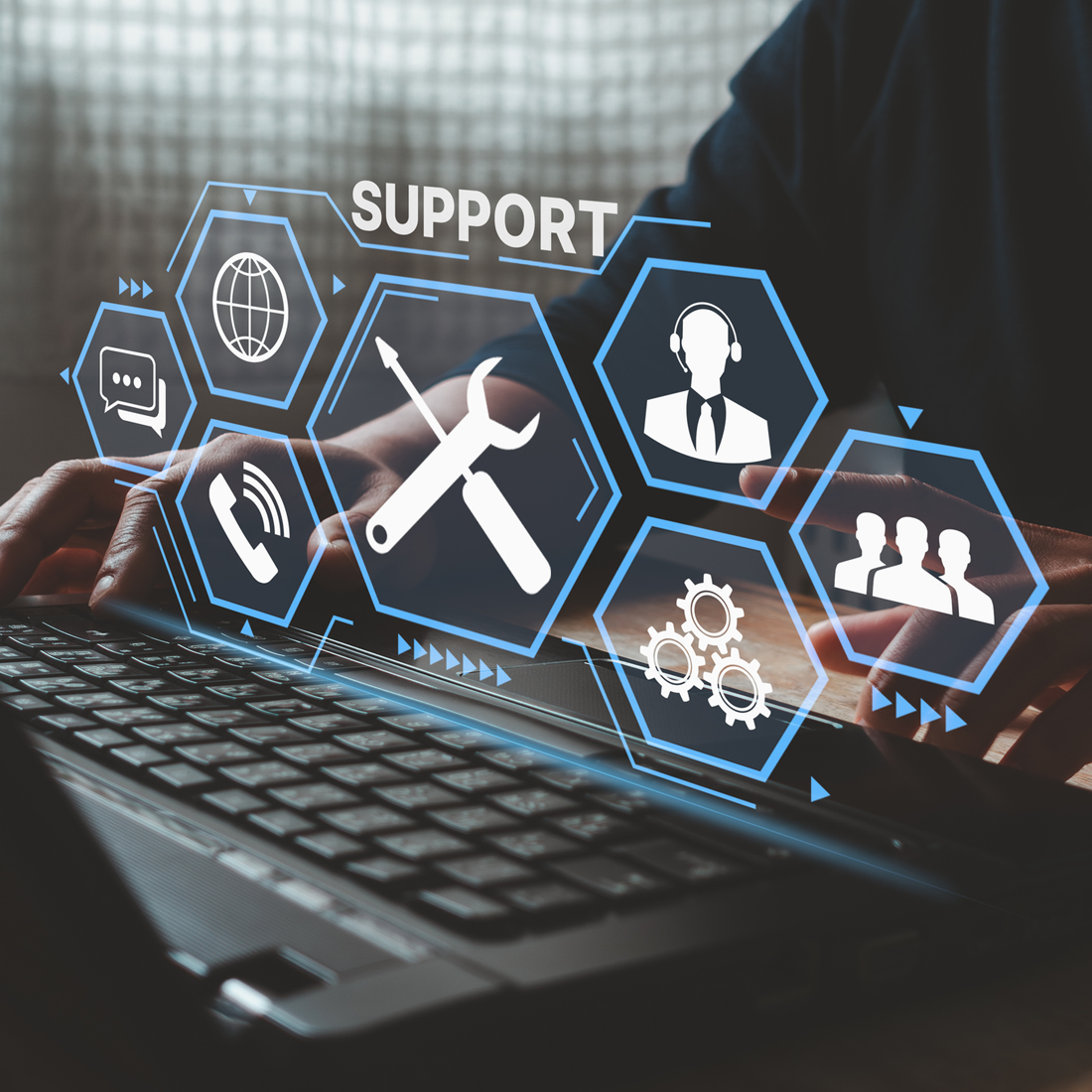 Mains tapant sur un clavier d'ordinateur portable avec icônes de support technique en surimpression.