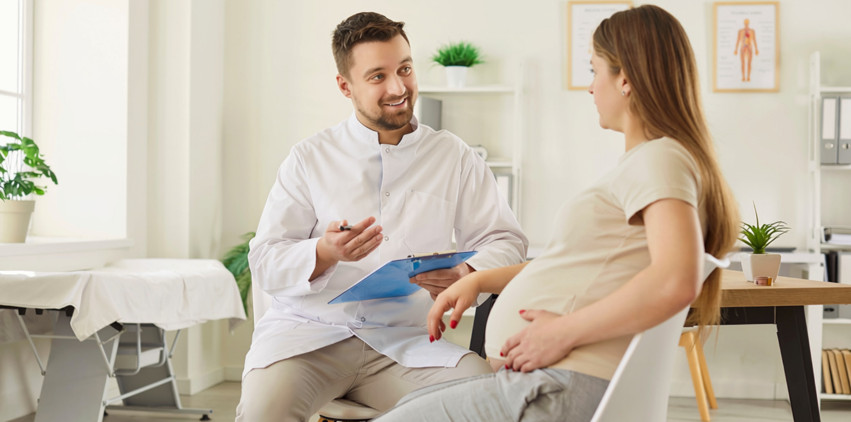 Un médecin souriant en blouse blanche parle avec une femme enceinte assise dans un cabinet médical lumineux, tenant un dossier bleu.
